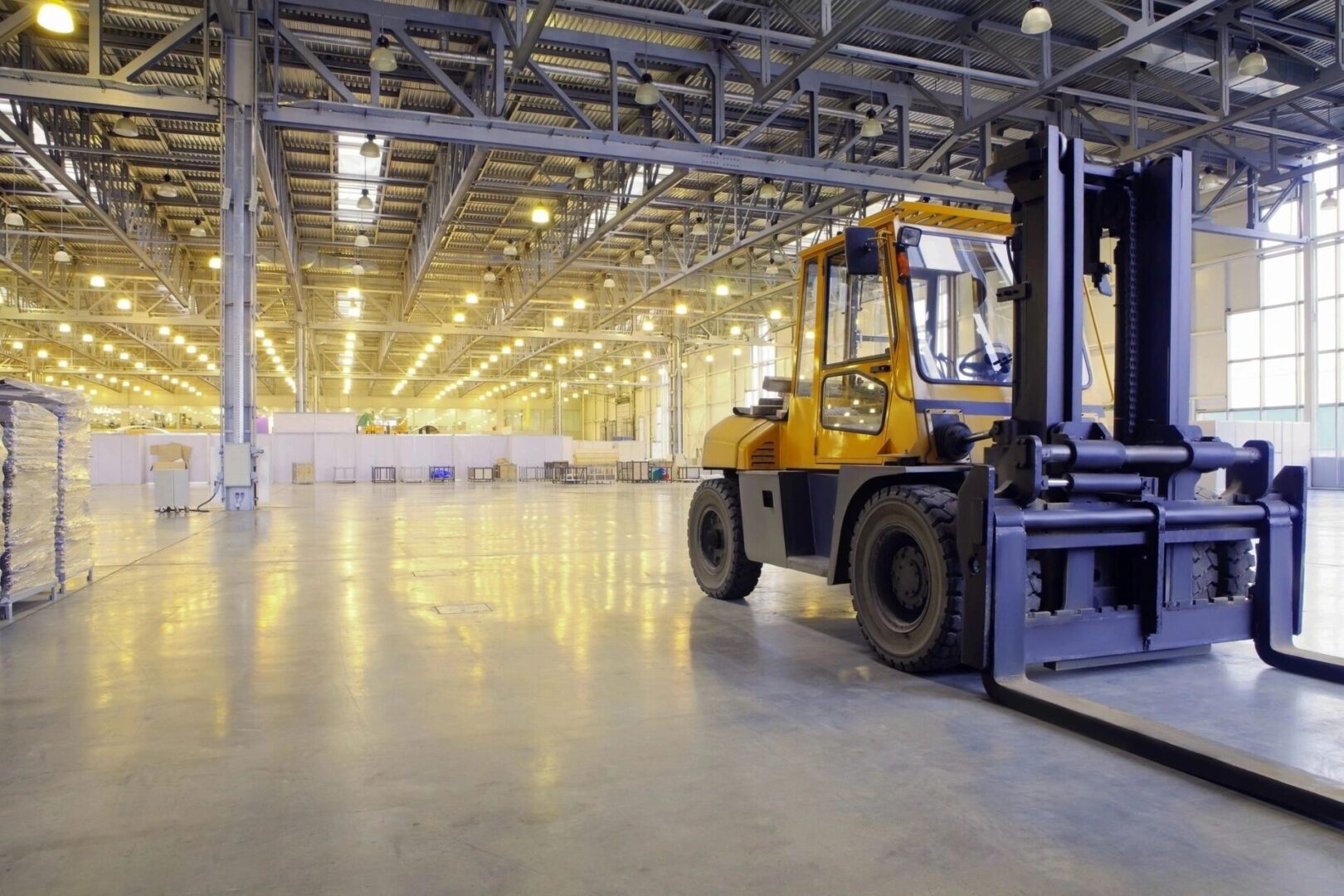 A forklift is parked in an empty warehouse.